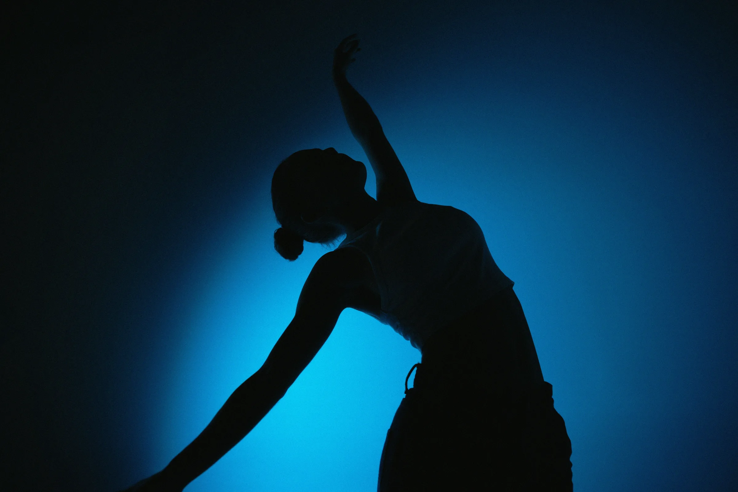 Dancer silhouetted in blue stage light