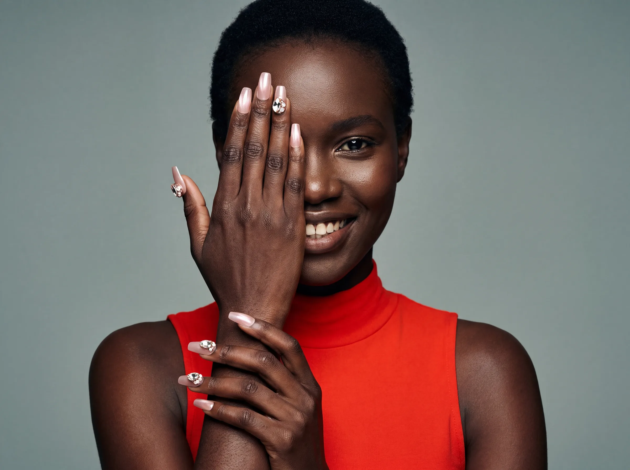 Model with a hand across her face, press-on nails